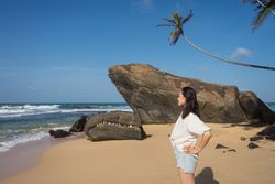 Woman in beachwear walking on sand barefoot