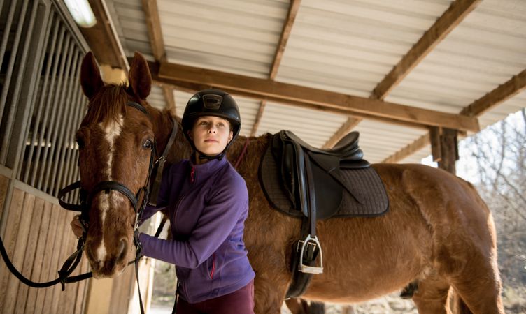 Woman and girl brushing horse