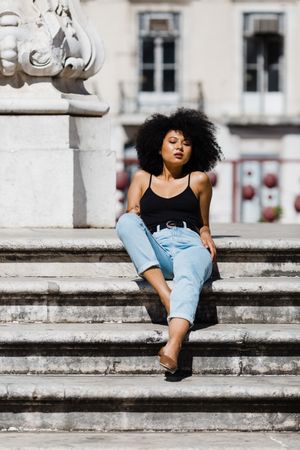 Black female sitting on stairs outdoors