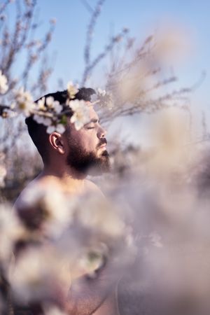 Shirtless man meditating in spring garden