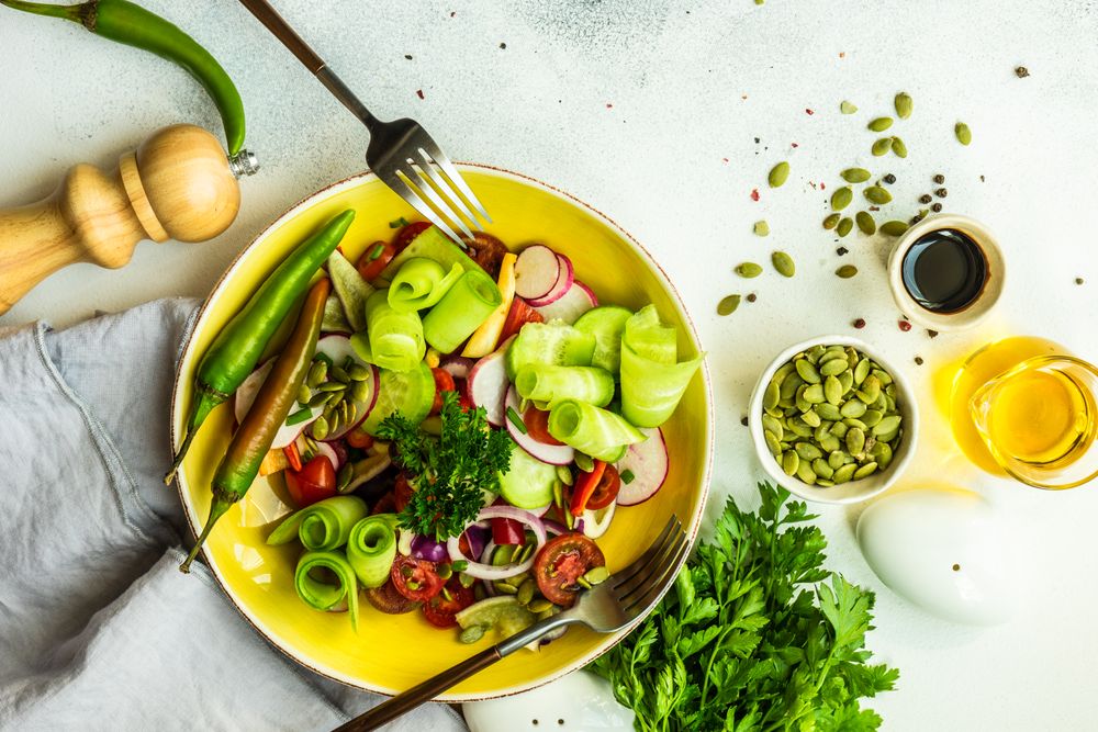 Fresh raw salad with chopped vegetables served with nuts and garnish