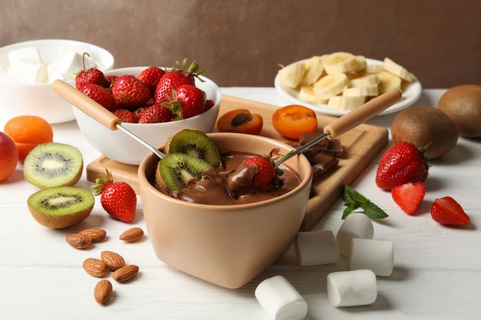 Composition with ingredients for chocolate fondue on wooden background. Cooking fondue