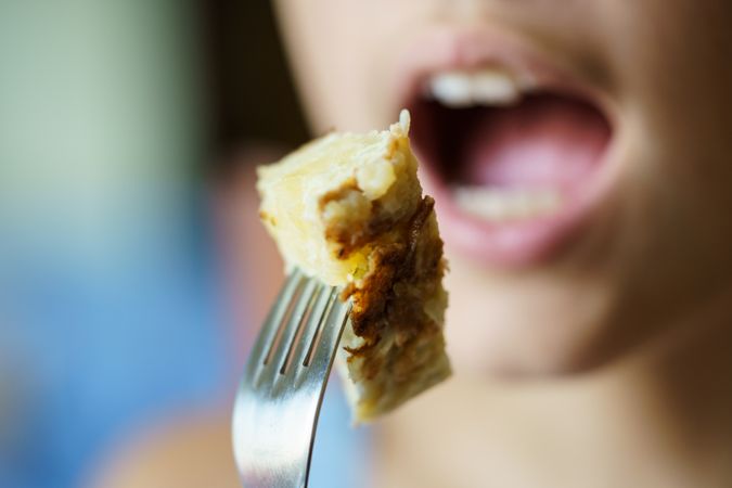 Girl biting into frittata