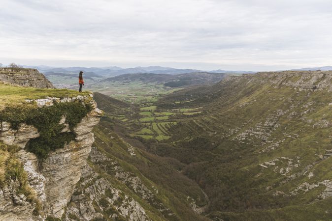 Man standing on cliff near valley