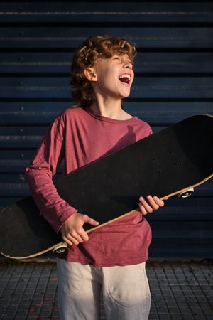 Excited boy with skateboard laughing