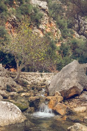 Small waterfall flowing into river in rocky mountainous valley i