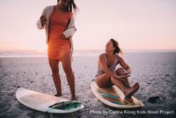 Two happy young women with surfboards at the beach Q4dPD4