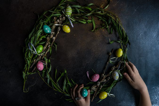 Hands of person creating a wreath for Easter time
