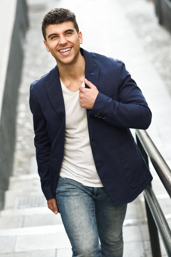 Smiling man in navy jacket walking up stairs