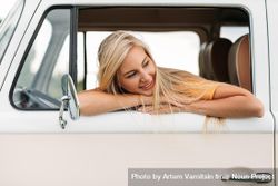 Woman looking back and leaning out vehicle window 0WZ6jb