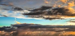 Dark grey clouds surrounding light blue sky