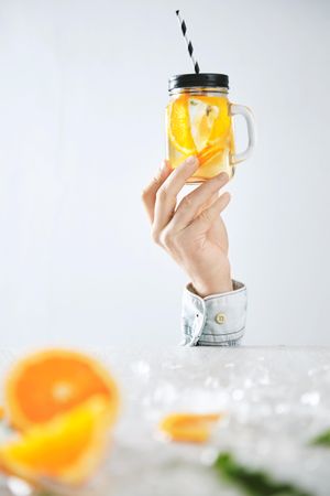 Hand holding up infused orange water