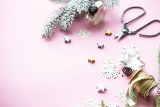 Christmas decorations of snowflakes and stars on pink background with copy space