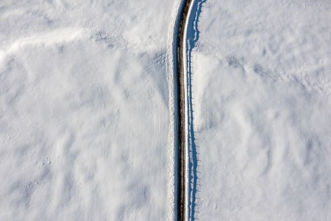 Road passing through a snow-covered valley, aerial image in the Bavarian Alps, Germany