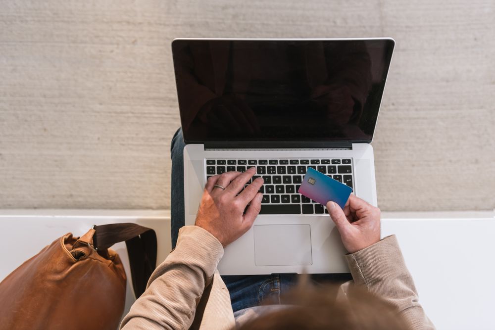 Crop businessman shopping online on street