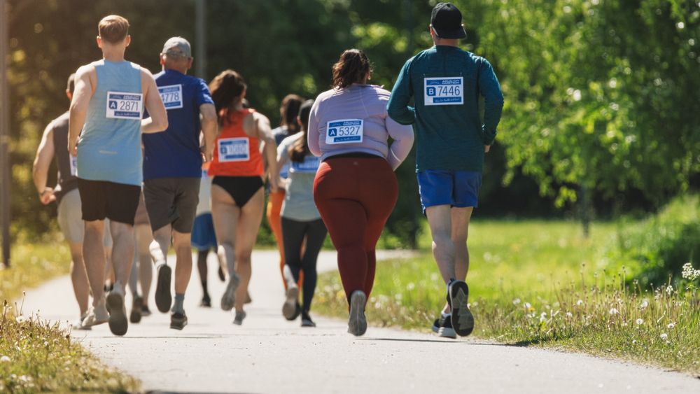 Group of People Running Through Park Health Trail and Participating in a Marathon with Dedication