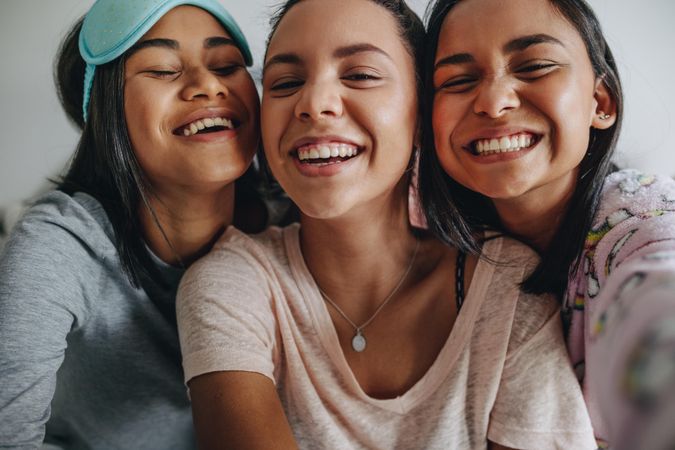 Young women having fun smiling for a selfie during slumber party