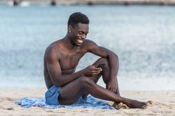 Man holding phone at the beach