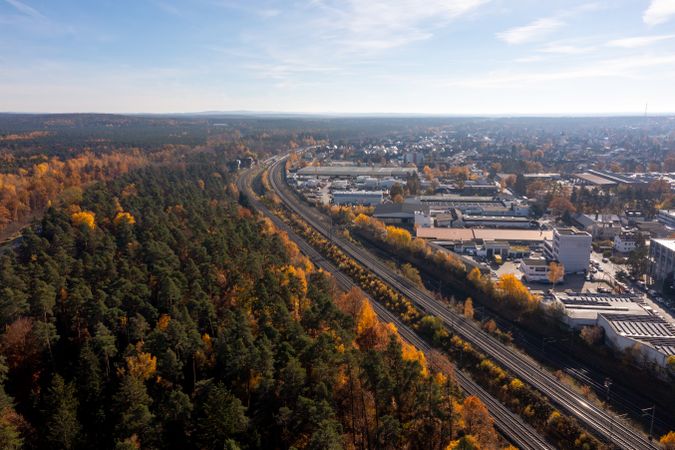 Drone aerial view with railways through autumn forest near Nuremberg city.