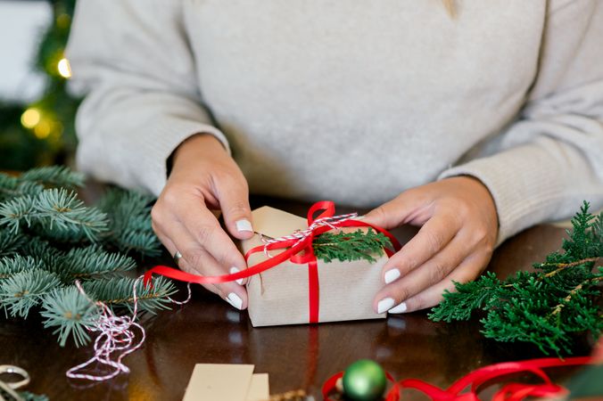 An unrecognizable woman holding Christmas gift in hand