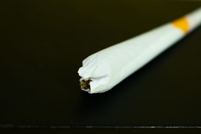 Rolled cigarette on dark table