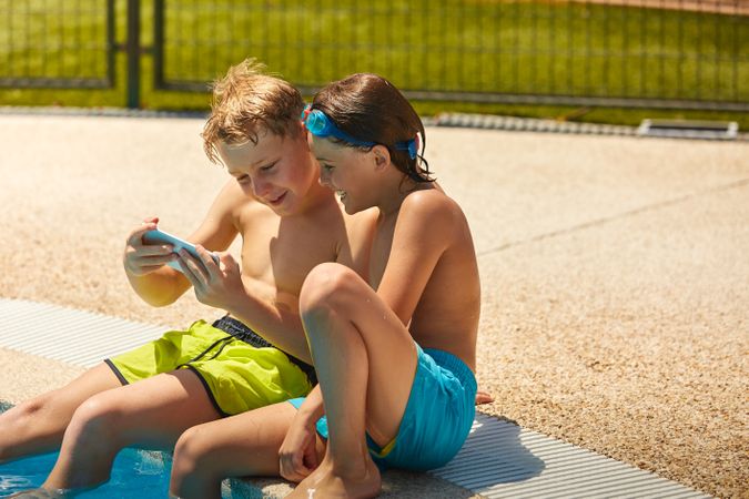 Boys on poolside taking selfie