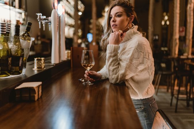 Stylish woman drinking wine in bar