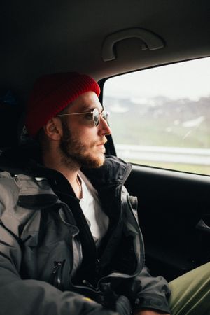 Male in sunglasses enjoying scenery from car window