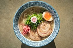 Delicious ramen soup with soft egg and pork meat in bowl