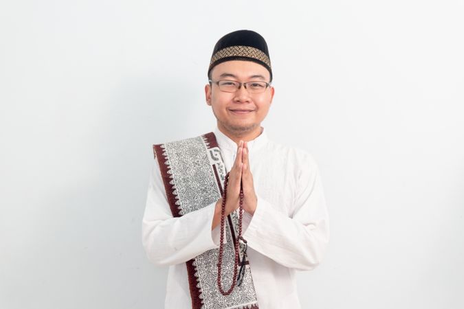 Asian Muslim man smiling doing greeting pose during Ramadan