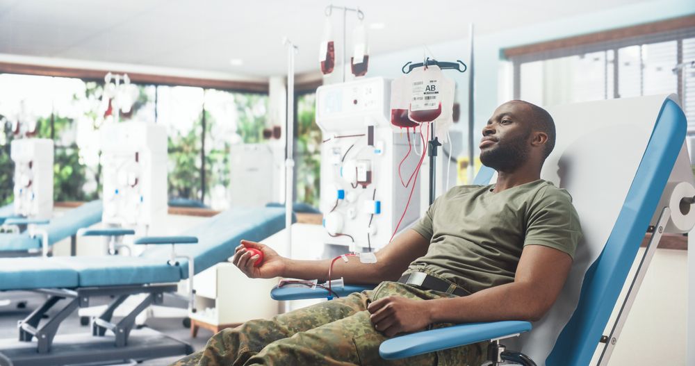 Black Male Army Soldier Donating Blood For Injured Comrades In Military Hospital.