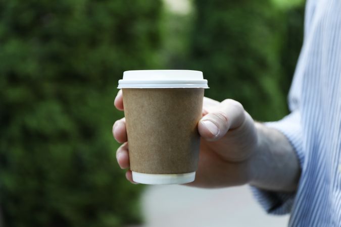 Young man holding a cup of coffee. Space for text