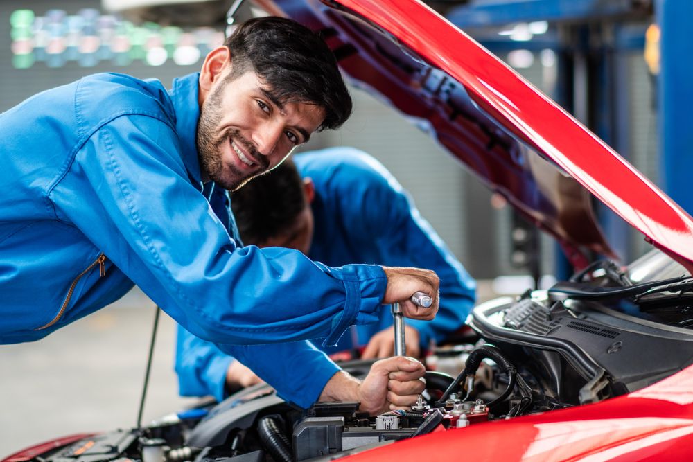 Automobile mechanic man checking car damage under bonnet