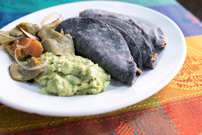 Mexican tacos made with blue corn tortillas, prickly pear, onion, carrot and guacamole