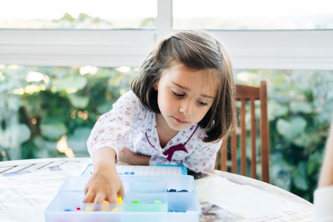 Girl playing with mosaic board game