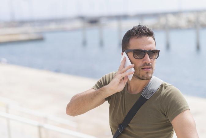 Male looking around while talking on cellphone with space for text