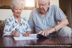 Mature couple signing documents 4A636b