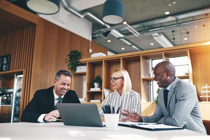 Group of smiling people discussing work in an office