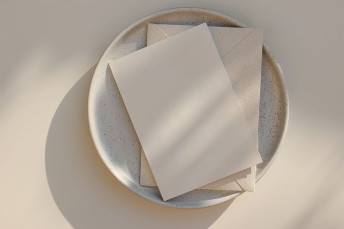 Mock up invitation with envelope on plate with shadows