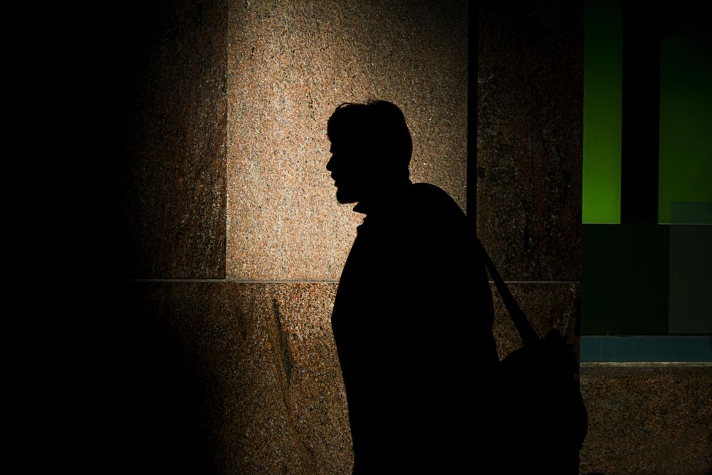 Silhouette of man on brown wall