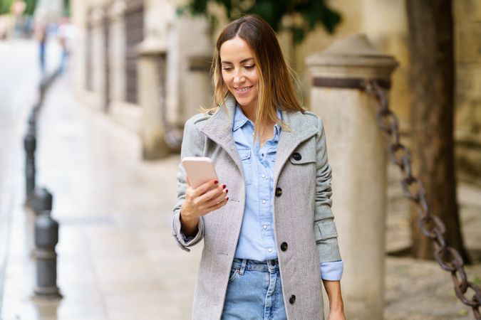 Smiling female watching video on city street