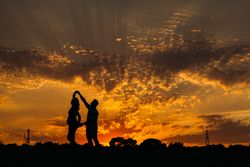 Anonymous couple dancing during sunset