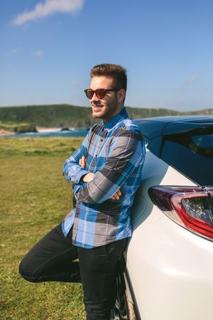 young man leaning on his car