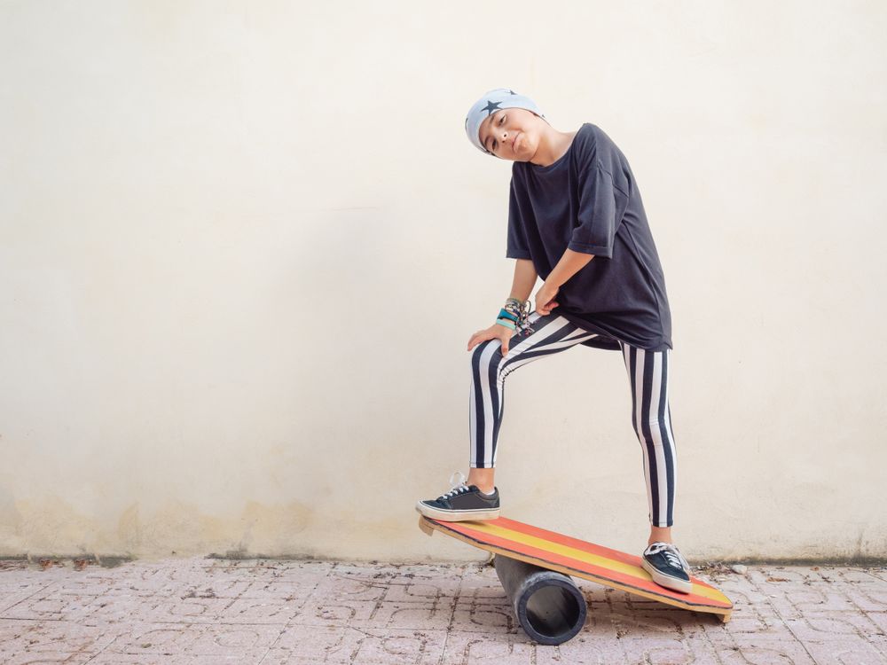 Cheeky boy standing on colorful board and swinging