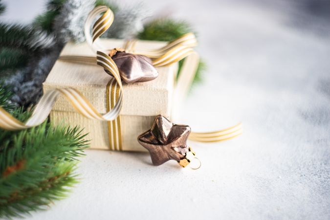 Christmas present with gold ribbon and star decorations on marble counter