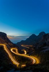 long exposure road at night between mountains
