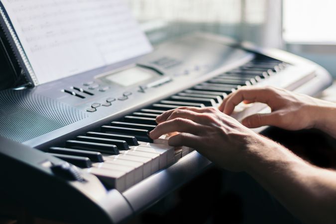 man playing piano with a music sheet