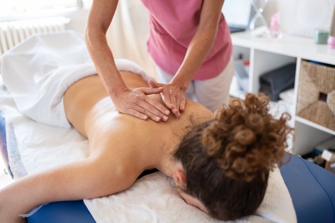 Woman getting spinal massage in clinic