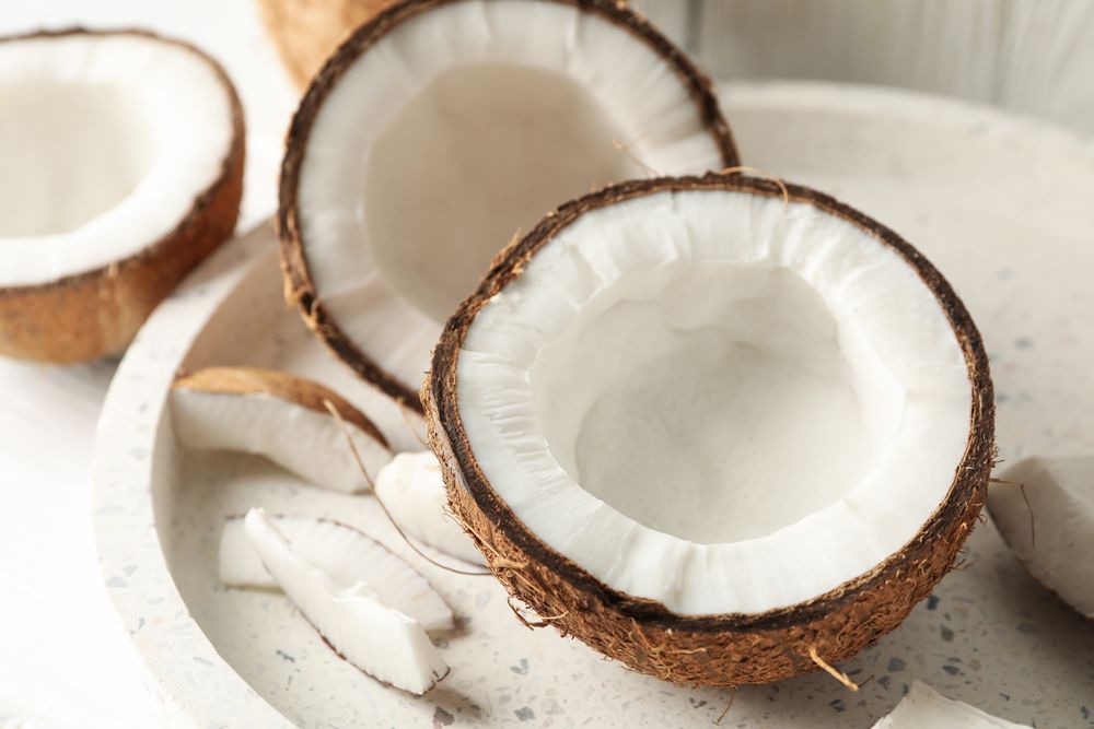 Tray with coconut on wooden background. Tropical fruit