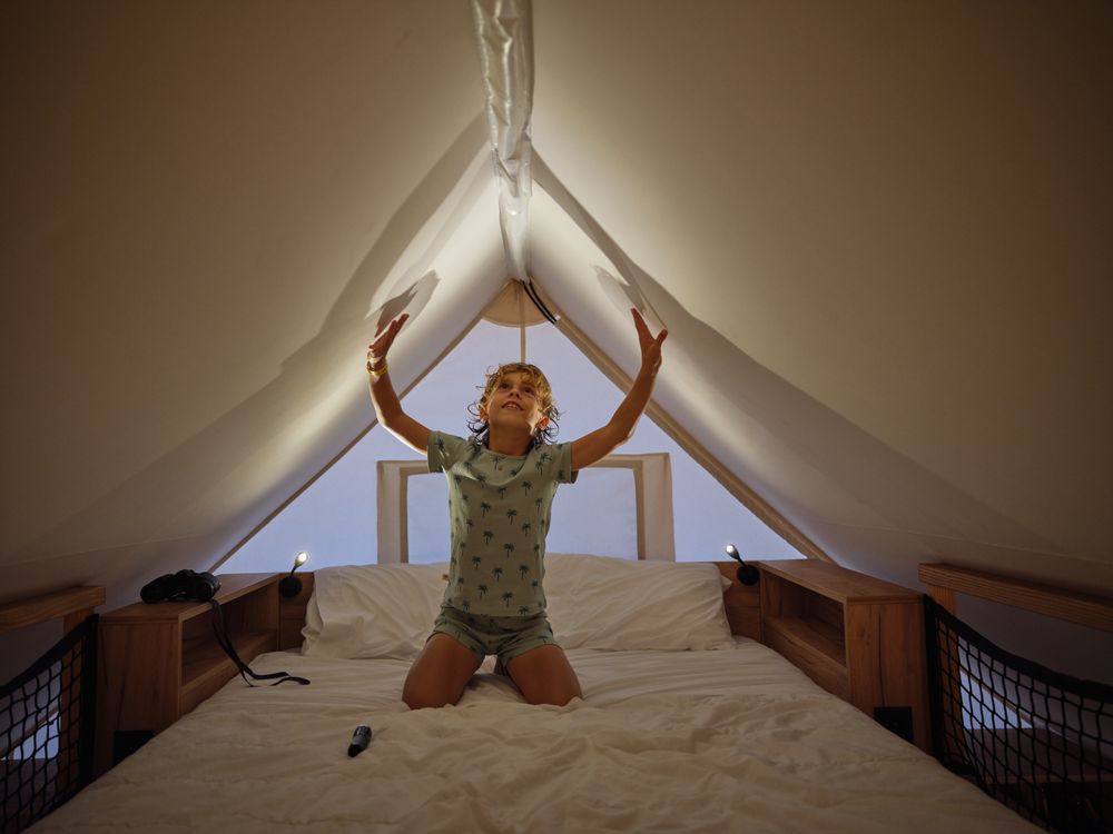 Cute boy touching ceiling on bed
